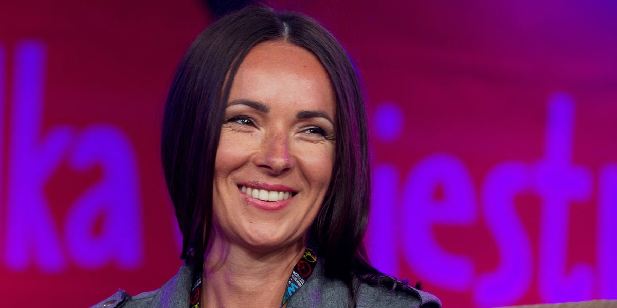 Kasia Kowalska. Na zdjęciu uśmiechnięta młoda kobieta w długich włosach