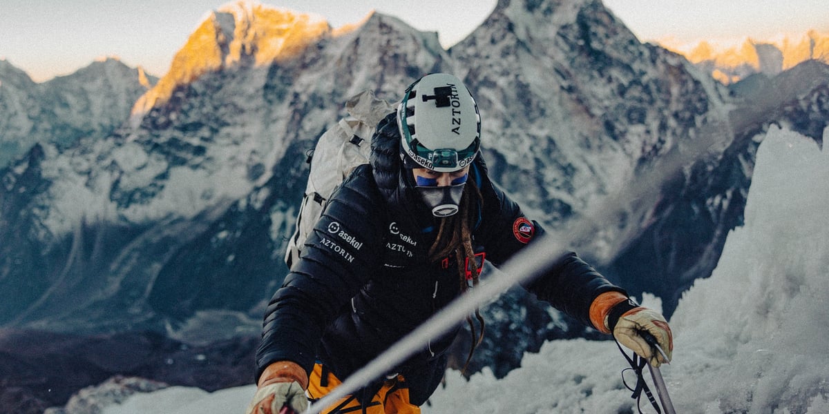 Mateusz Waligóra w czasie wejścia na Mount Everest. W tle wielkie, skaliste i ośnieżone szczyty Himalajów
