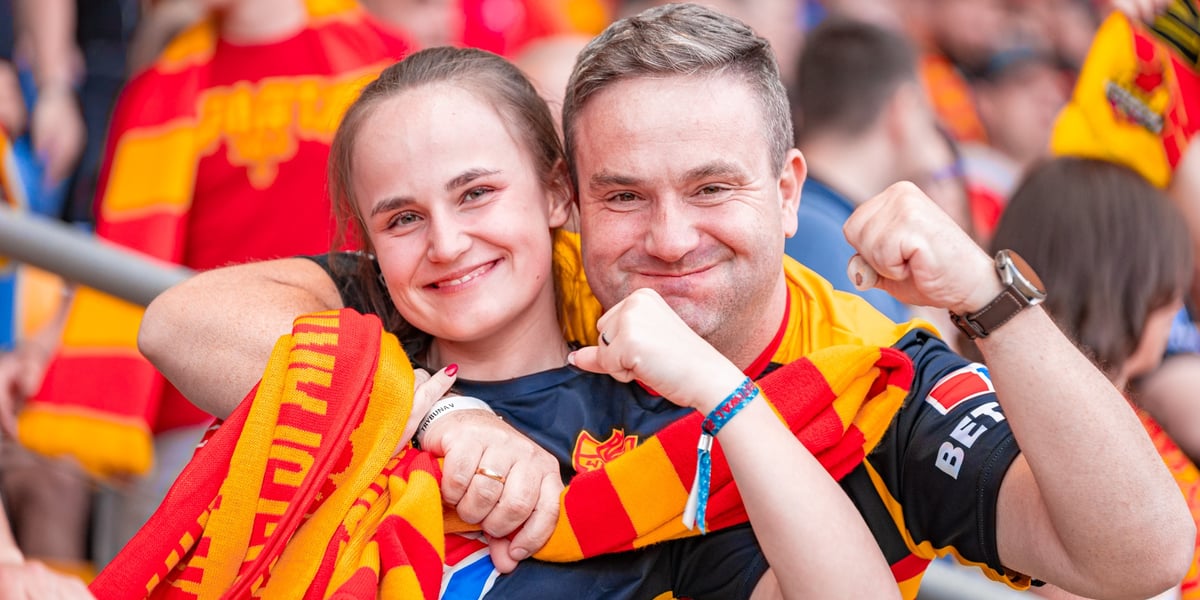 Uśmiechnięci kibice Sparty - kobieta i mężczyzna z szalikami na Olimpijskim