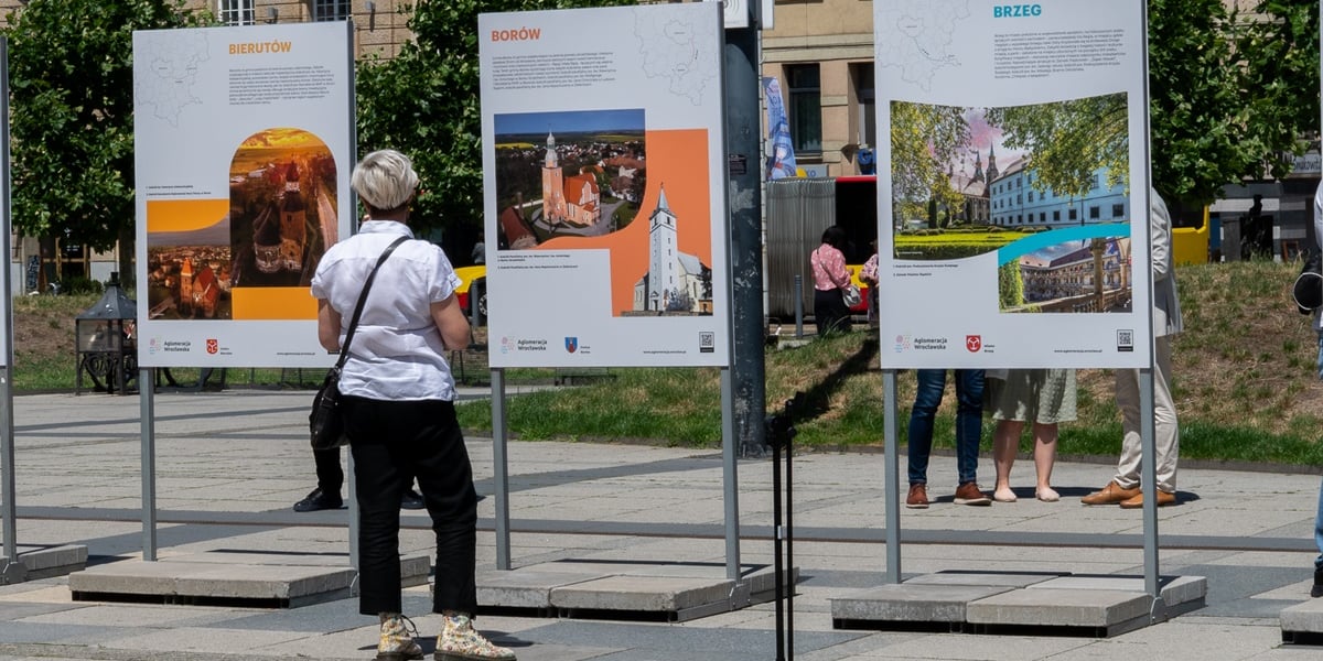 Wystawa "Perły Aglomeracji Wrocławskiej". Na zdjęciu kobieta ogląda część wystawy i dowiaduje się o atrakcjach miast Bierutów, Borów i Brzeg