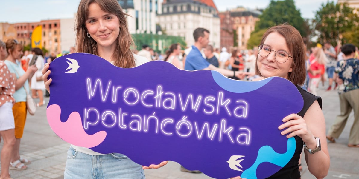 Dwoje instruktorów tańczy przed tłumem ludzi na placu Wolności we Wrocławiu