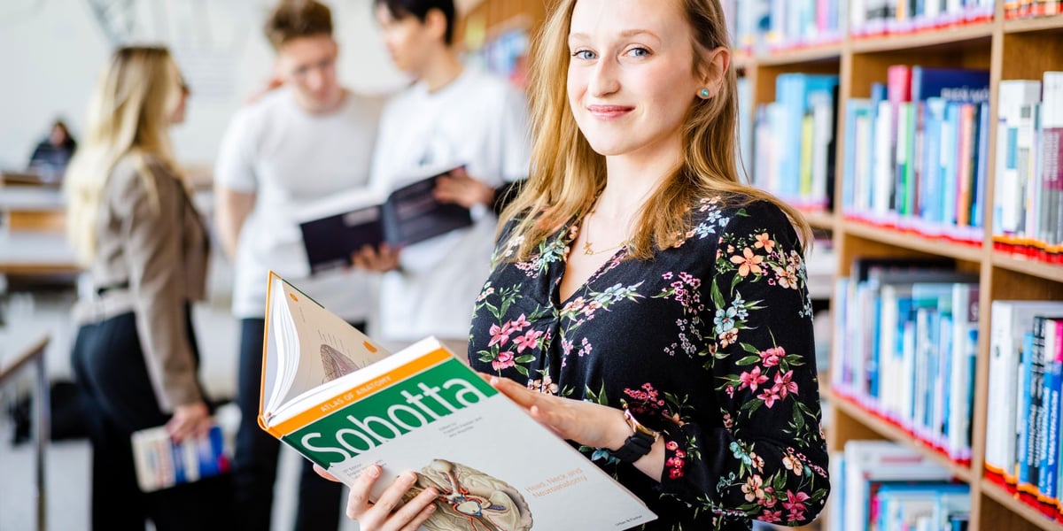 Studenci Uniwersytetu Medycznego we Wrocławiu. Na zdjęciu młoda kobieta z książką