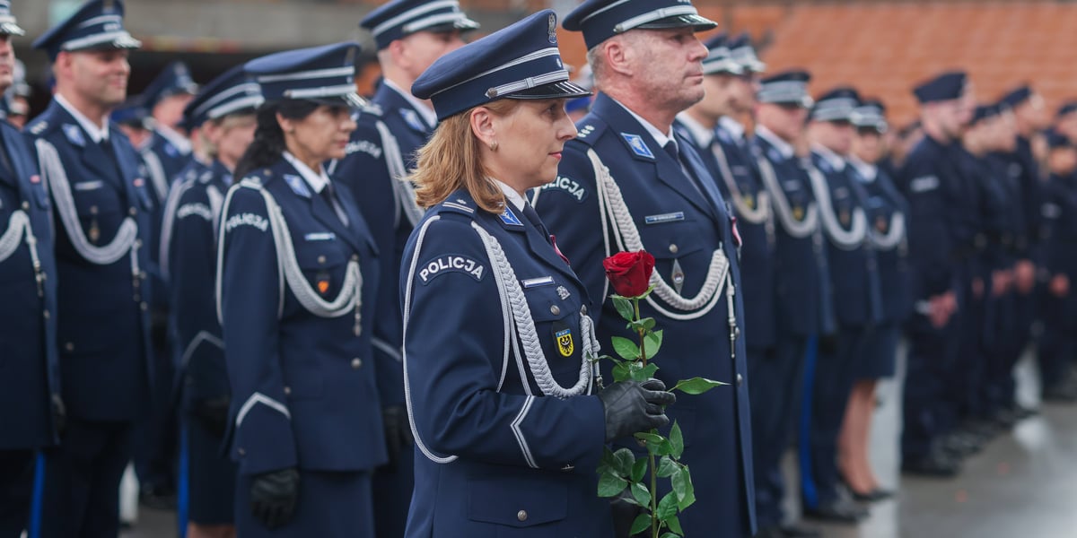 Policjantka w mundurze z różą, w tle policjantki i policjanci podczas uroczystości Święta Policji 2025 w Hali Stulecia