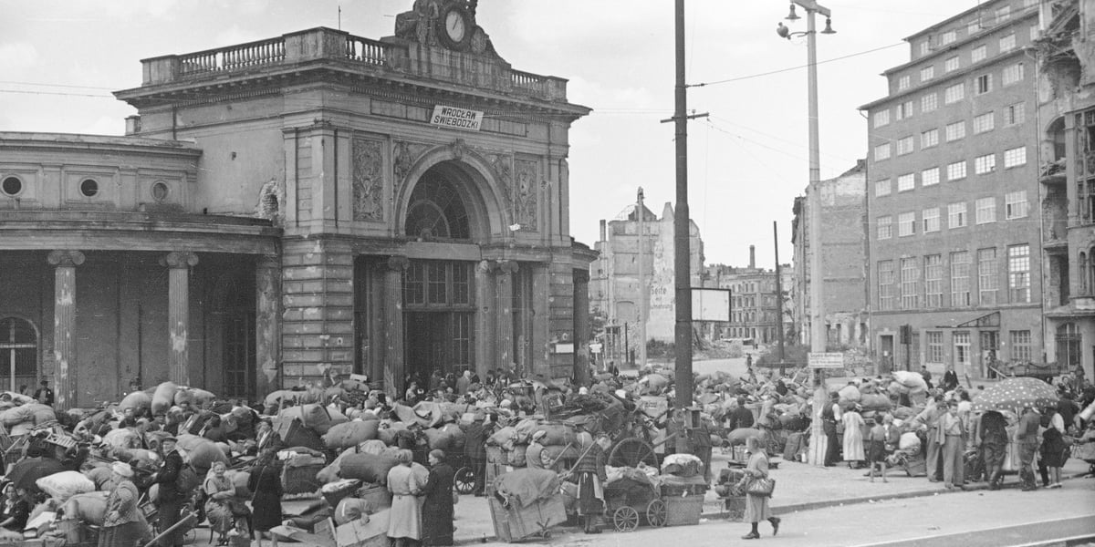Okolice Dworca Świebodzkiego we Wrocławiu, lata 40. Na zdjęciu tłum z wózkami i pakunkami przed budynkiem dworca