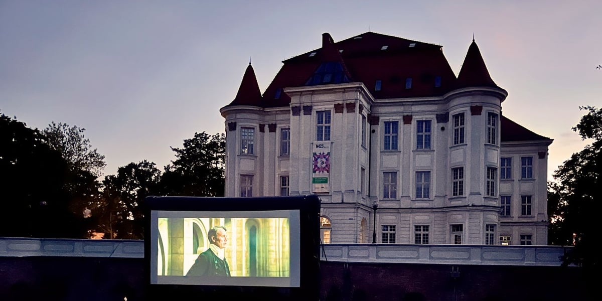 Pokazy filmowe w OPT Zamek na osiedlu Leśnica, na zdjęciu zabytkowy budynek, ustawiony przed nim ogromny ekran