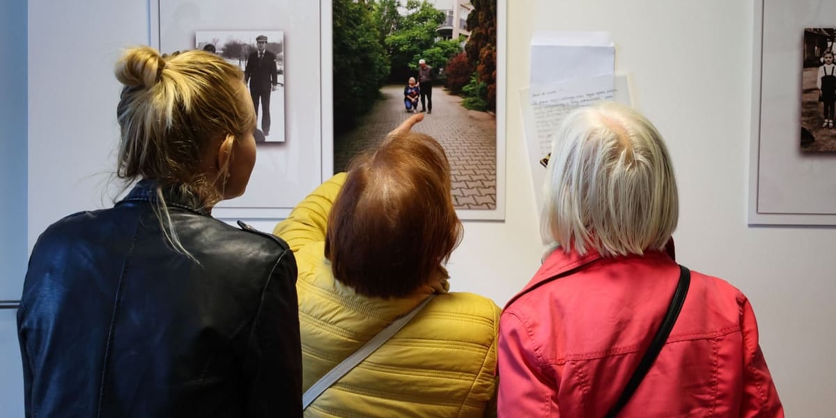 Mikrogranty, uczestniczki projektu "Wspomnienia z dzieciństwa" na Swojczycach. Na zdęciu trzy kobiety oglądające wystawę archiwalnych zdjęć z osiedla.
