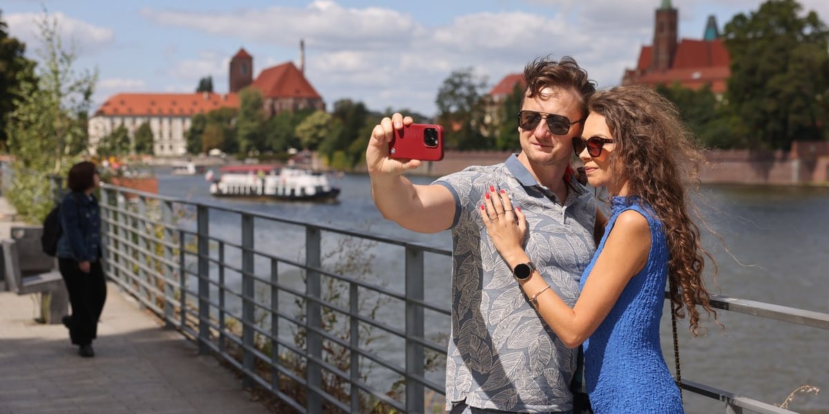 Lato w mieście. Spacerowicze robią sobie zdjęcia na tle panoramy Ostrowa Tumskiego