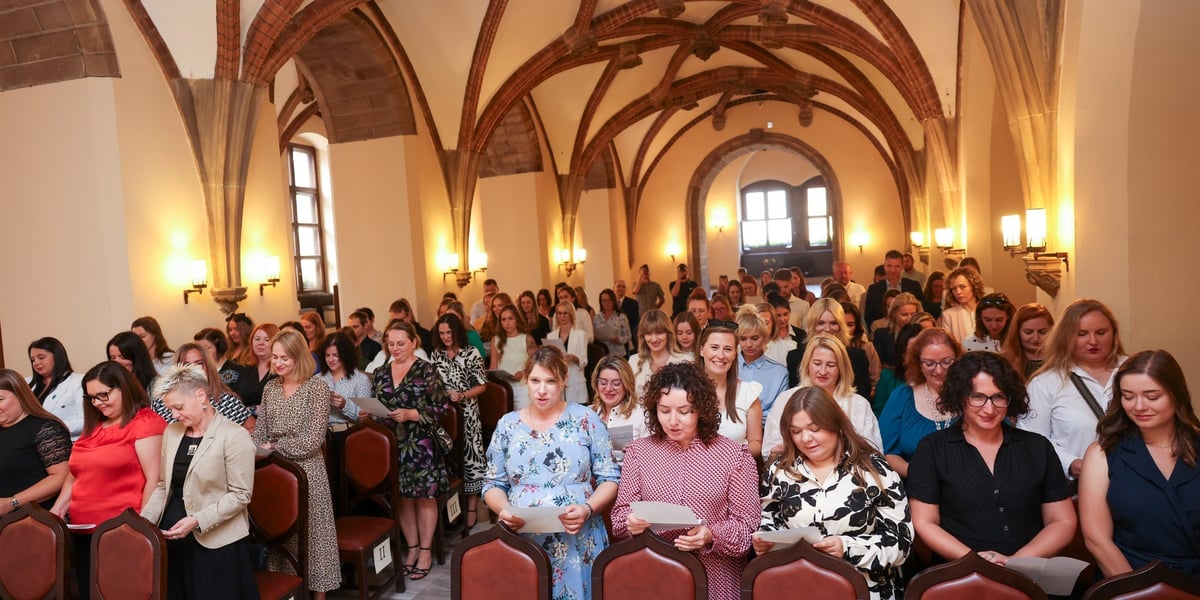 Nauczyciele, którzy odebrali dziś awans - osoby z kartkami odczytujące przysięgę
