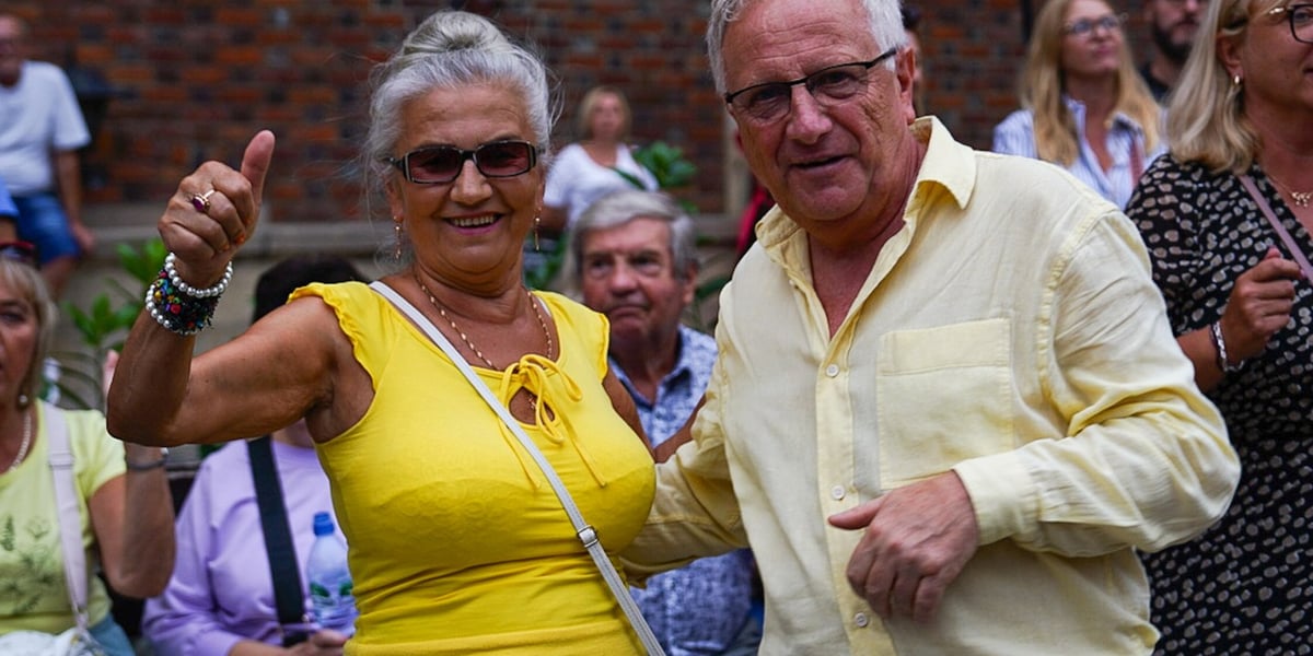 Kobieta i mężczyzna, w tle tańczący ludzie. Potańcówka na Rynku we Wrocławiu, 30.08.2025 r.  