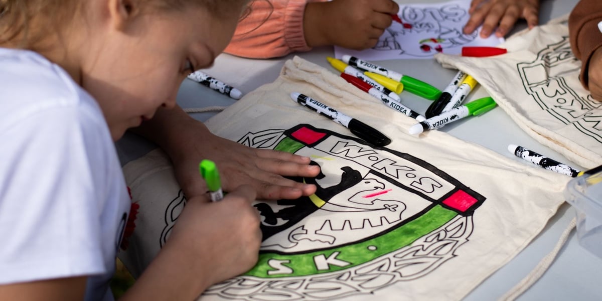 Dziewczynka kolorująca herb WKS Śląsk Wrocław