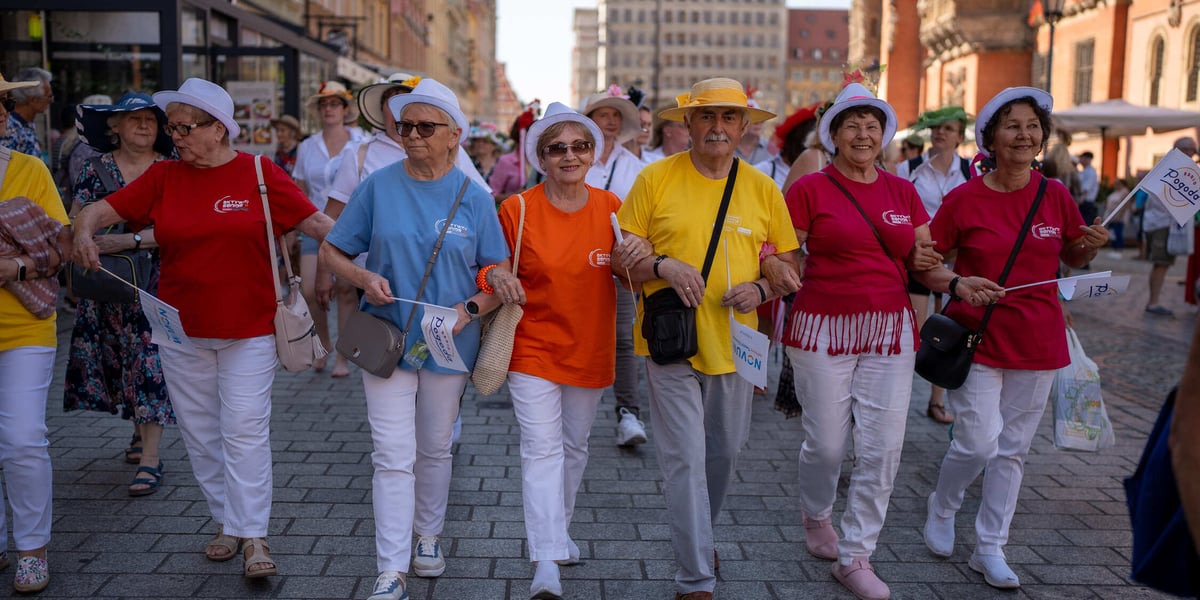 Uczestnicy Dni Seniora na wrocławskim Rynku - wszyscy w białym spodniach, kolorowych koszulkach i kapeluszach