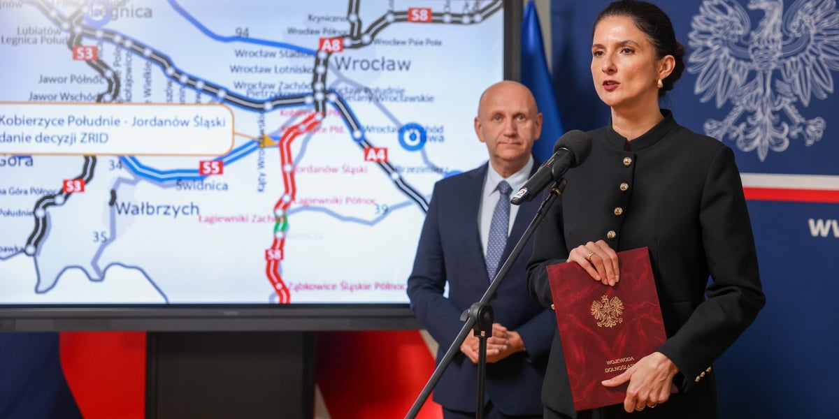 Anna Żabska, wojewoda dolnośląska. Na zdjęciu kobieta podczas spotkania z dziennikarzami, w tyle szkic dróg