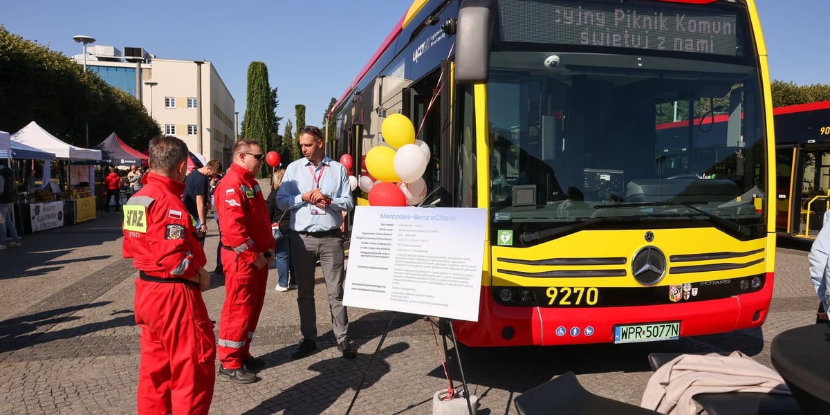 Aglomeracyjny Piknik Komunikacyjny. Na zdjęciu nowoczesny autobus i kilka osób przy nim, które rozmawiają