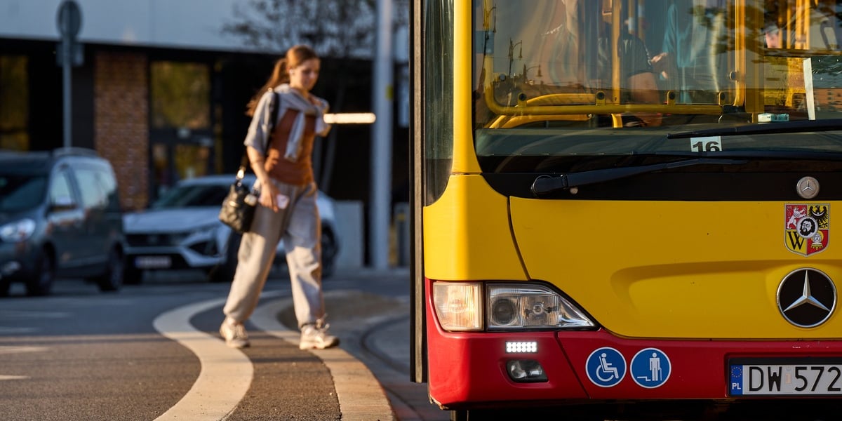 Na zdjęciu dziewczyna wsiada do autobusu miejskiego. Zdjęcie ilustracyjne