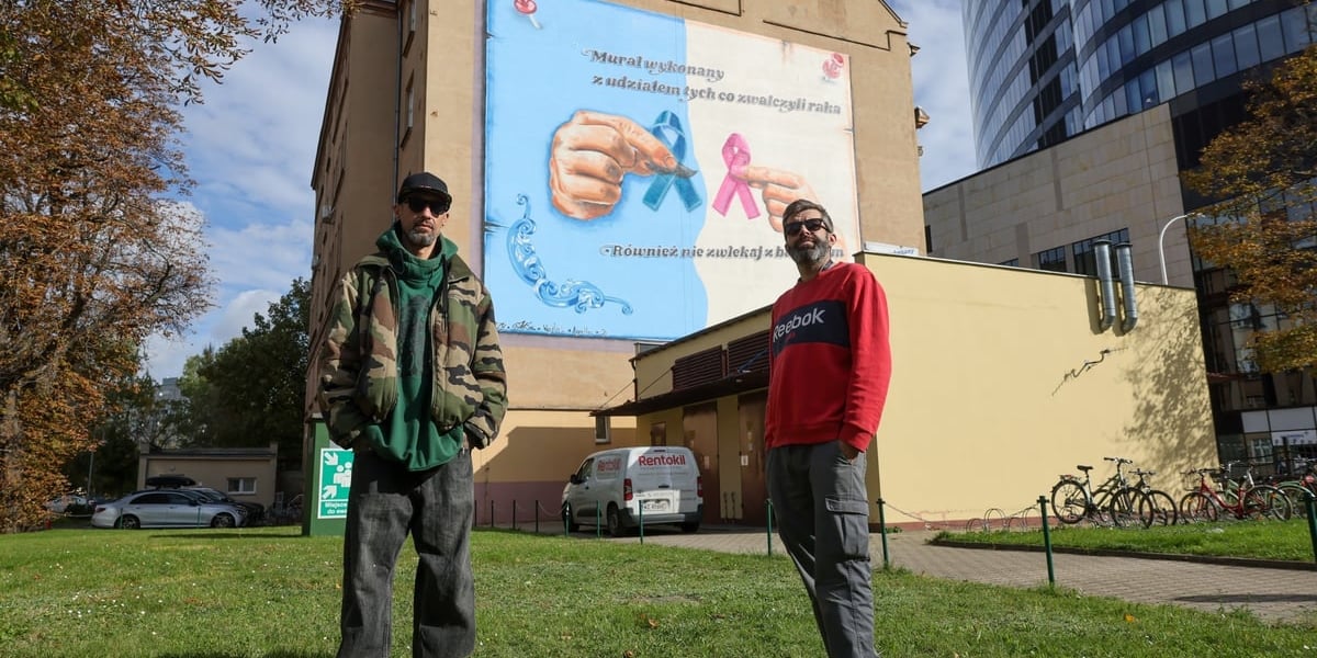Sebastian Szlachetka (po lewej) i Mariusz Sahe na tle ubiegłorocznego muralu na szpitalu. Sebastian Szlachetka jest wykonawcą także tegorocznego, Skrzydeł Mocy, który pokażemy w niedzielę po jego odsłonięciu.