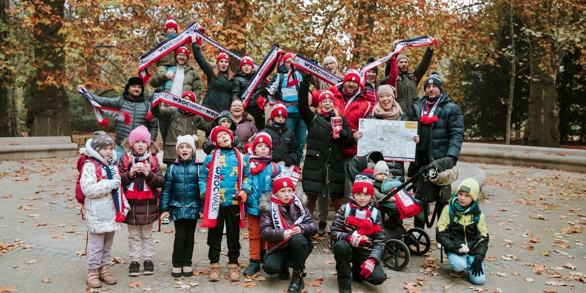 Zdjęcia z jednej z poprzednich edycji wydarzenia WrocWalk: grupa ludzi (w tym dzieci), w tle jesienny krajobraz