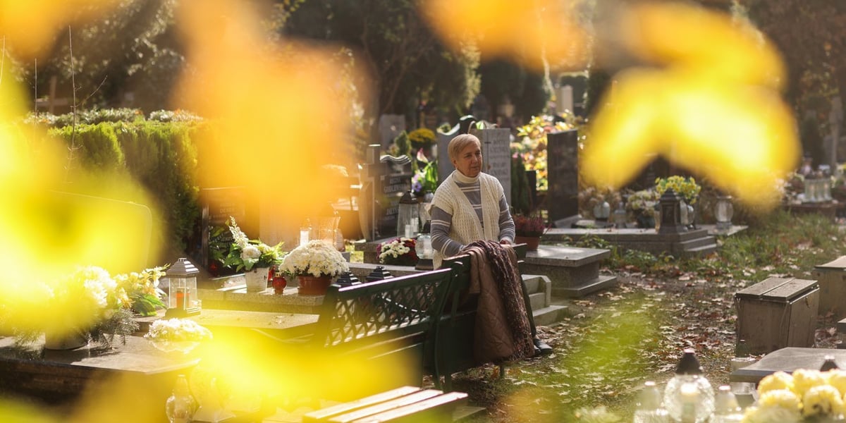 Liście i kobieta przy grobach na cmentarzu Grabiszyńskim, 1 listopada 2025