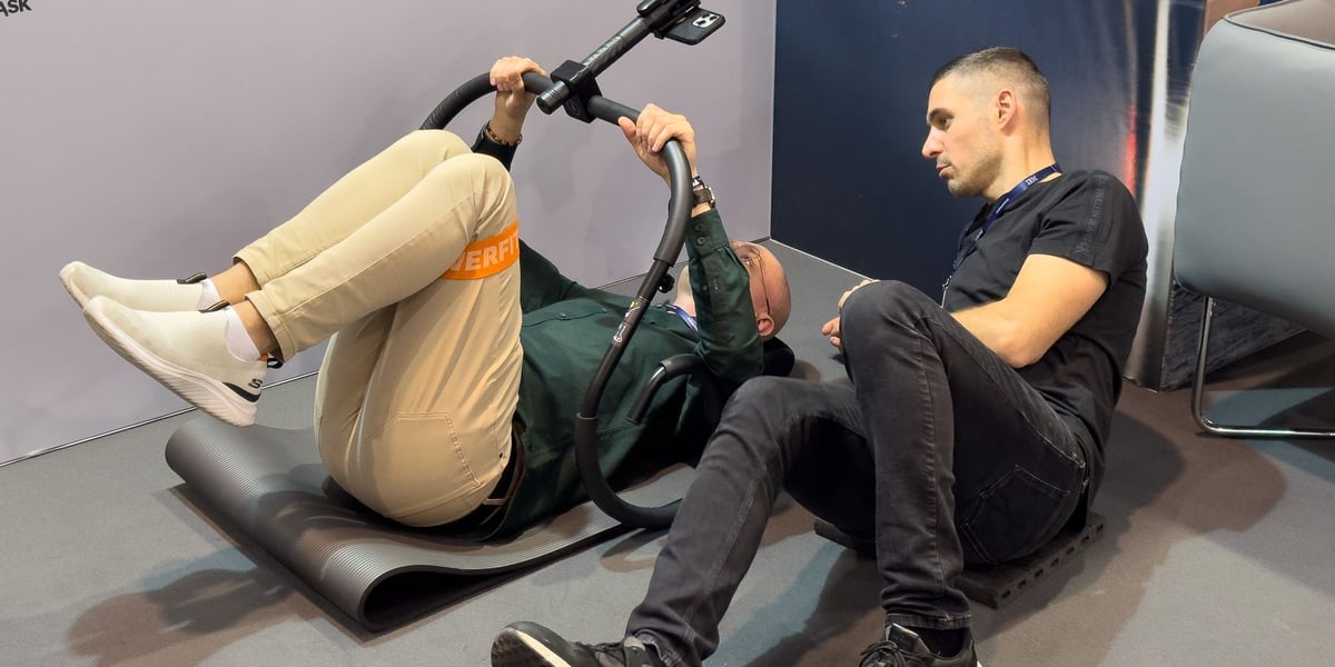 Dwóch mężczyzn leży na ziemi - twórca startupu BackApp (tryVinci) pokazuje klientowi jak działa jego produkt