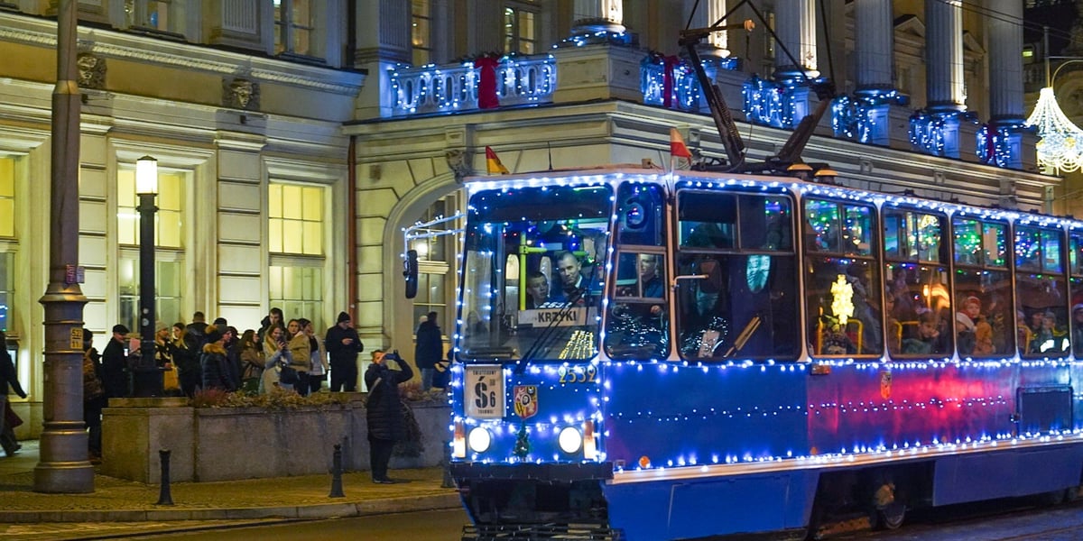 Tramwaj ozdobiony światełkami jedzie ulicą koło Opery.