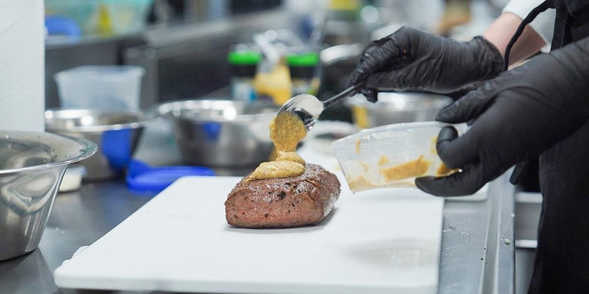 Jedno z konkursowych dań na talerzu i dłonie kucharza, 5 grudnia 2025