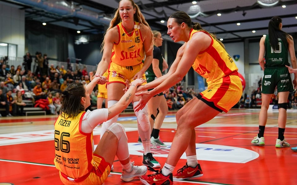 Dwie koleżanki pomagają wstać z parkietu Dominice Fiszer podczas meczu w Ślęza Arenie, 18 styczna 2026