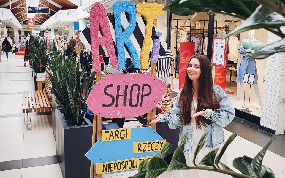 Na zdjęciu kobieta przy stoisku Targi Rzeczy Niepospolitych Artishop 