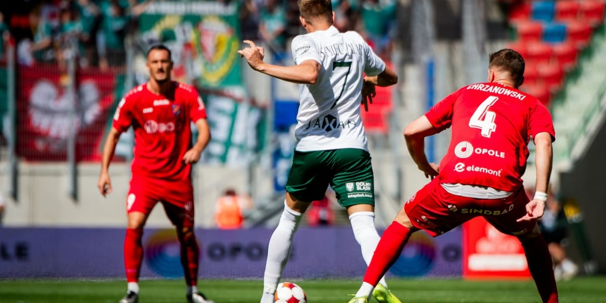 Zdjęcie ilustracyjne przedstawiające trzech piłkarzy na boisku w trakcie gry - mecz Śląsk Wrocław - Odra Opole.