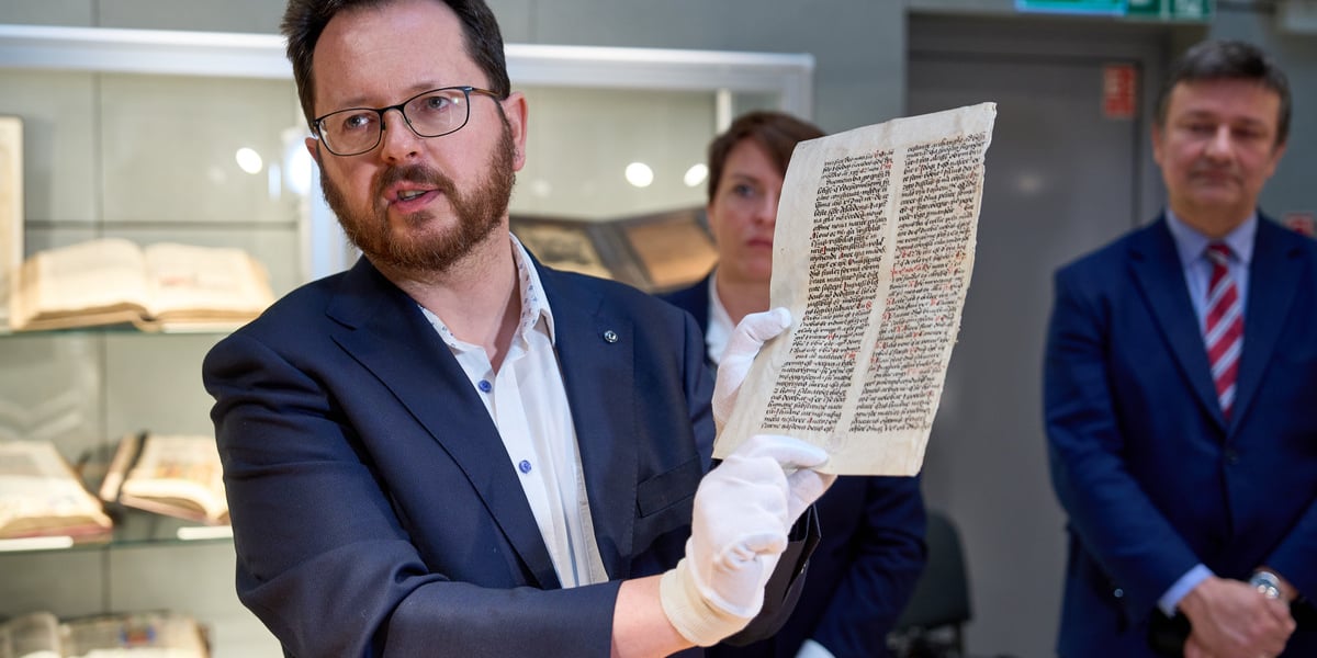 Dr Antoine Haaker, pracownik Biblioteki Uniwersyteckiej, odnalazł rękopis dzieł św. Augustyna w paryskiej galerii  Les Enluminures. Na zdjęciu mężczyzna w okularach trzyma stronę rękopisu