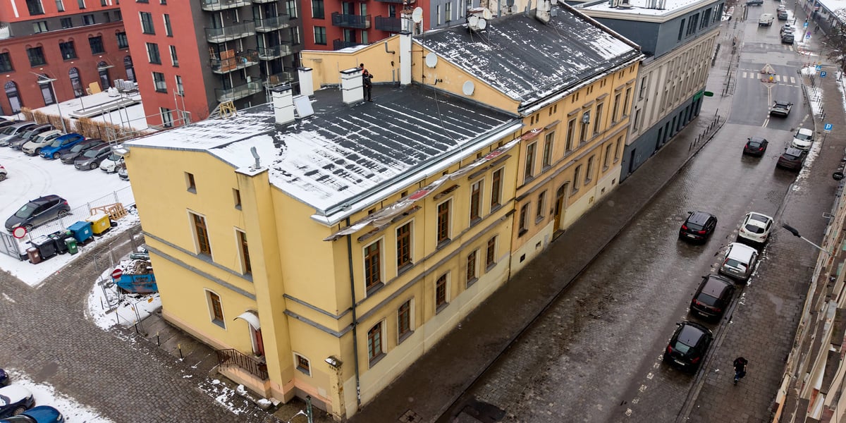 Remontowany dach kamienicy nr 33 przy ul. Tęczowej, pokryty śniegiem