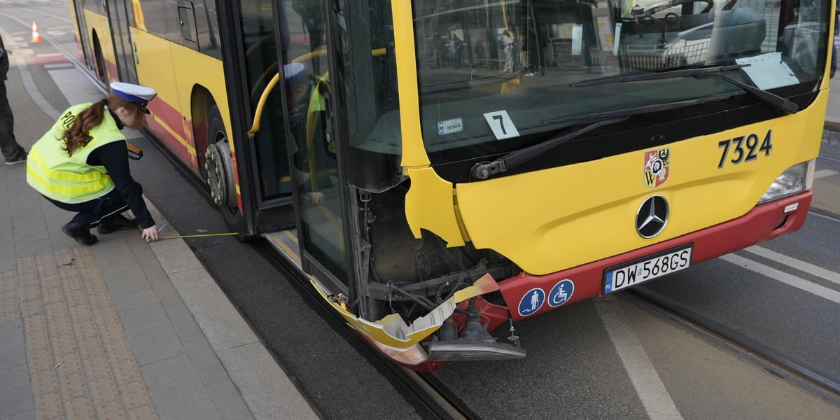 Policjantka sprawdza ślady na autobusie, który brał udział w wypadku