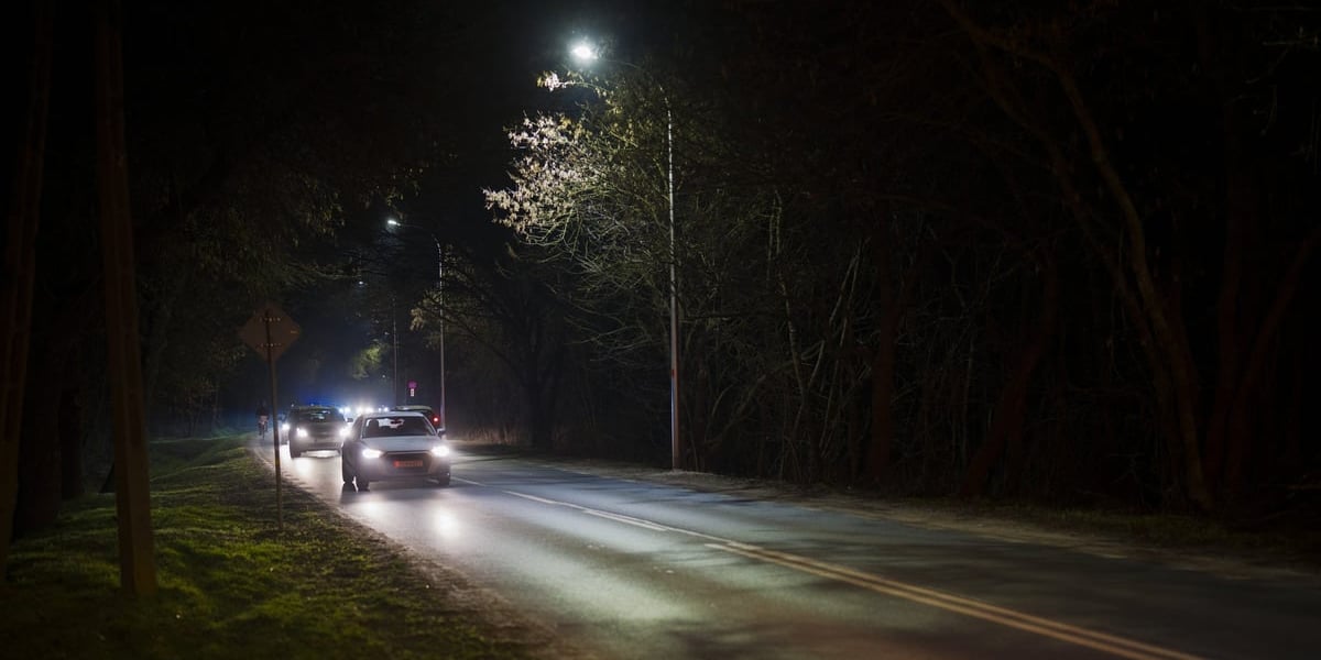 Zdjęcie przedstawiające ulicę oświetlona latarniami i jadące samochody - ul. Mościckiego z nowymi latarniami na Brochowie.