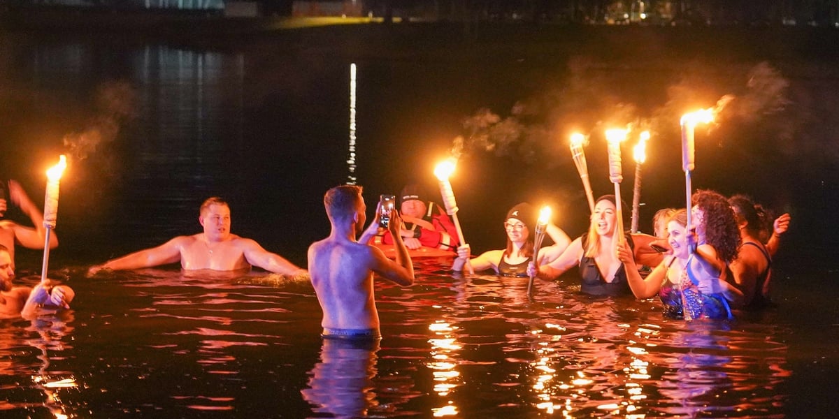 Na zdjęciu ludzie w wodzie z pochodniami podczas morsowania 21 marca - Kopalnia Wrocław Strfa Wakacji