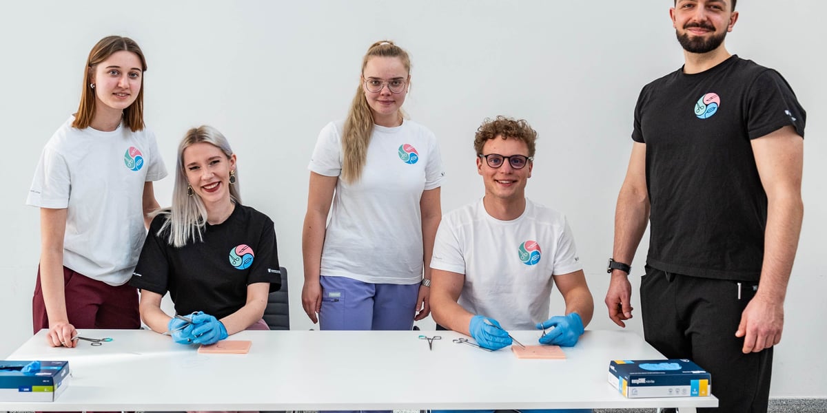 Studenci z Koła Naukowego Chirurgii Naczyniowej, Ogólnej i Transplantacyjnej. Na zdjęciu wokół stołu siedzą i stoją młodzi ludzie