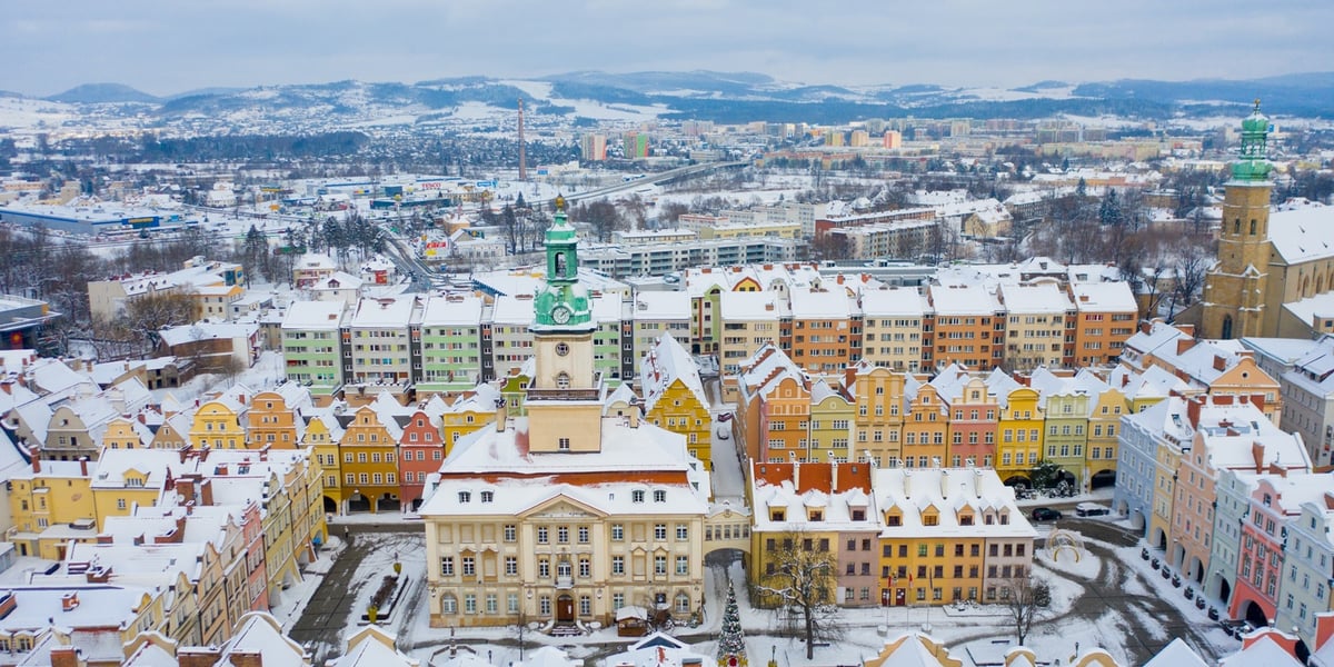 Na zdjęciu kamienice w centrum Jeleniej Góry i panorama gór w głębi