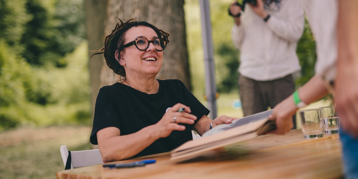 Olga Tokarczuk przy stole podpisuje książkę na poprzednim Festiwalu Góry Literatury (zdjęcie ilustracyjne)