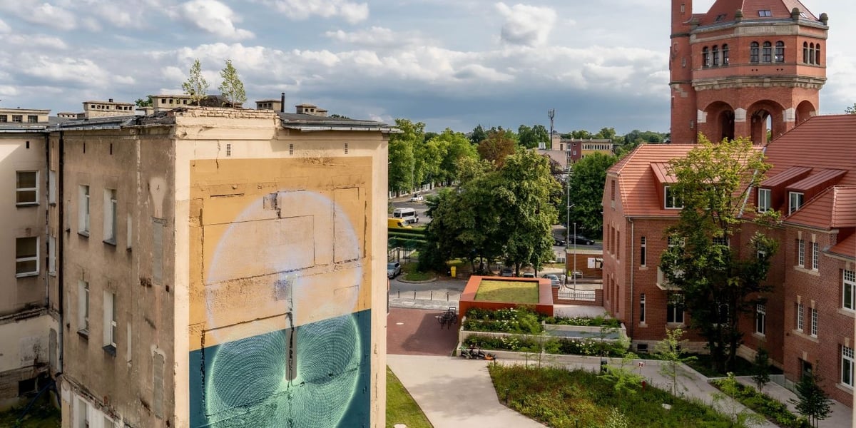 Na zdjęciu mural Łukasza Bergera na tle wieży ciśnień przy Wiśniowej