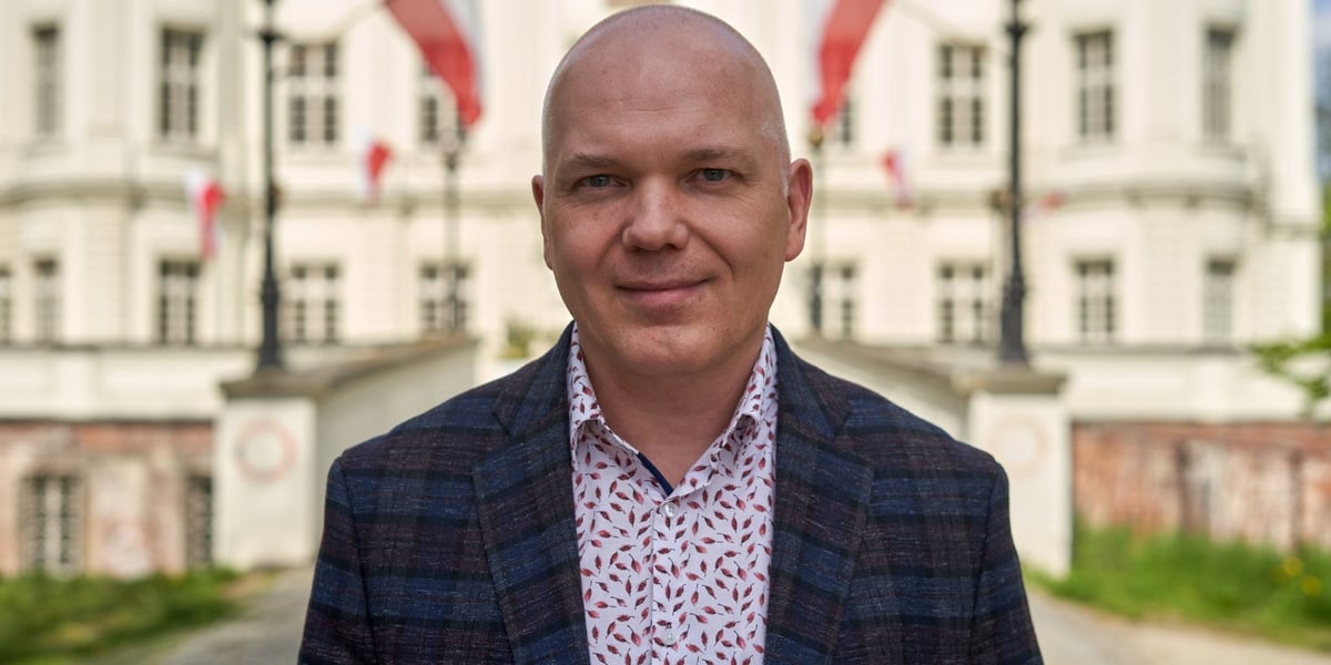 Paweł Kamiński, dyrektor OPT Zamek, na tle pałacu w Leśnicy