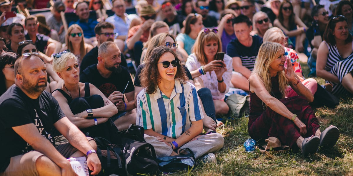 Publiczność siedząca na trawie podczas jednego ze spotkań Festiwalu Góry Literatury 2023. W pierwszym rzędzie, pierwsza z prawej - Monika Olejnik