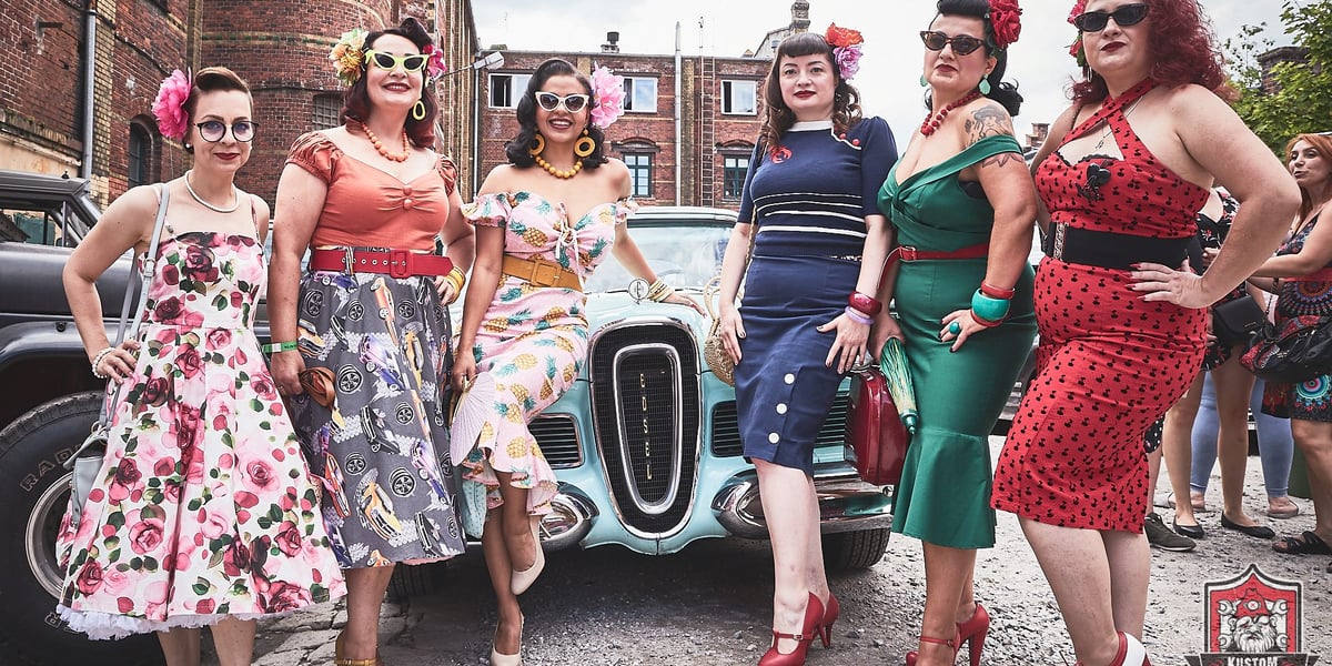 Rock'n'roll,  pojazdy z duszą i moda vintage. Kustom Konwent trwa przez weekend we Wrocławiu. Na zdjęciu widać kobiety w strojach z lat 50. i 60. XX wieku. Panie pozują na tle zabytkowego auta
