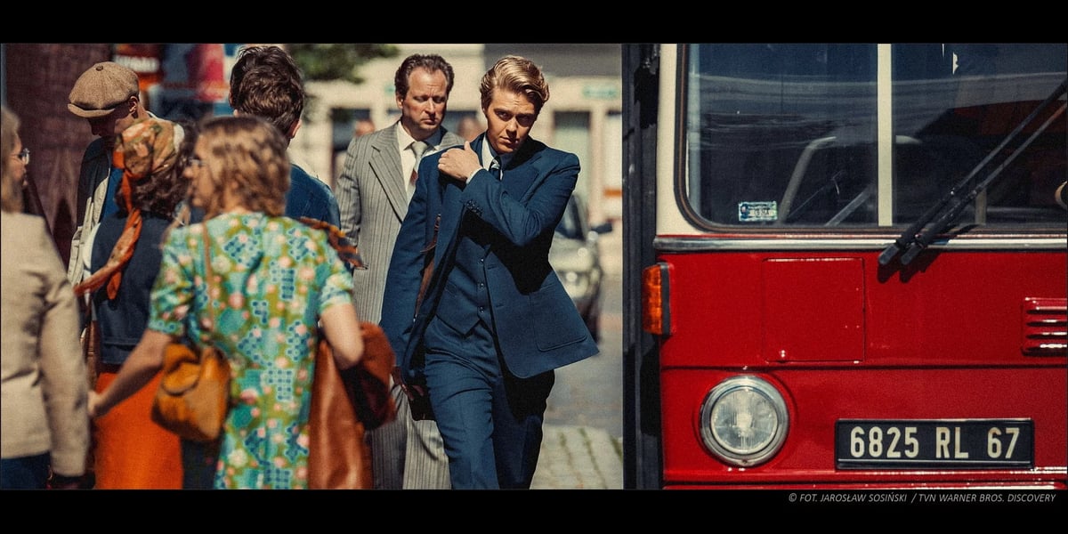 Aktor Jakub Gierszał w garniturze idzie ulicą mijając autobus, kadr z filmu „Doppelgänger. Sobowtór”