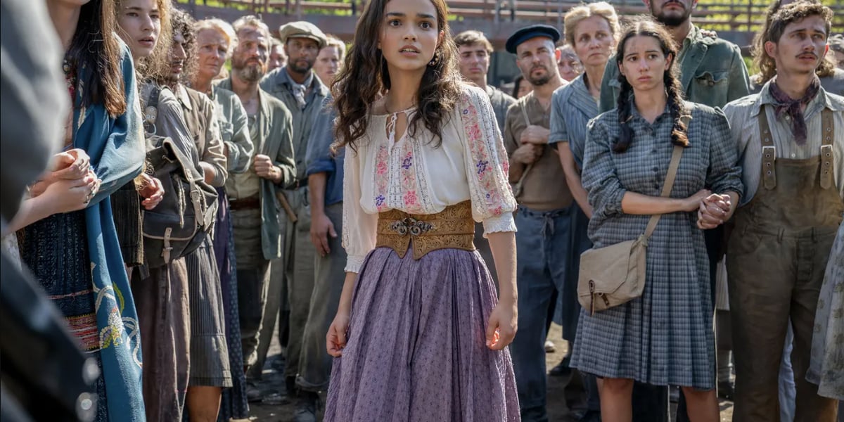  Lucy Gray, za nią stoją inne osoby mieszkające w Dystrykcie 12
