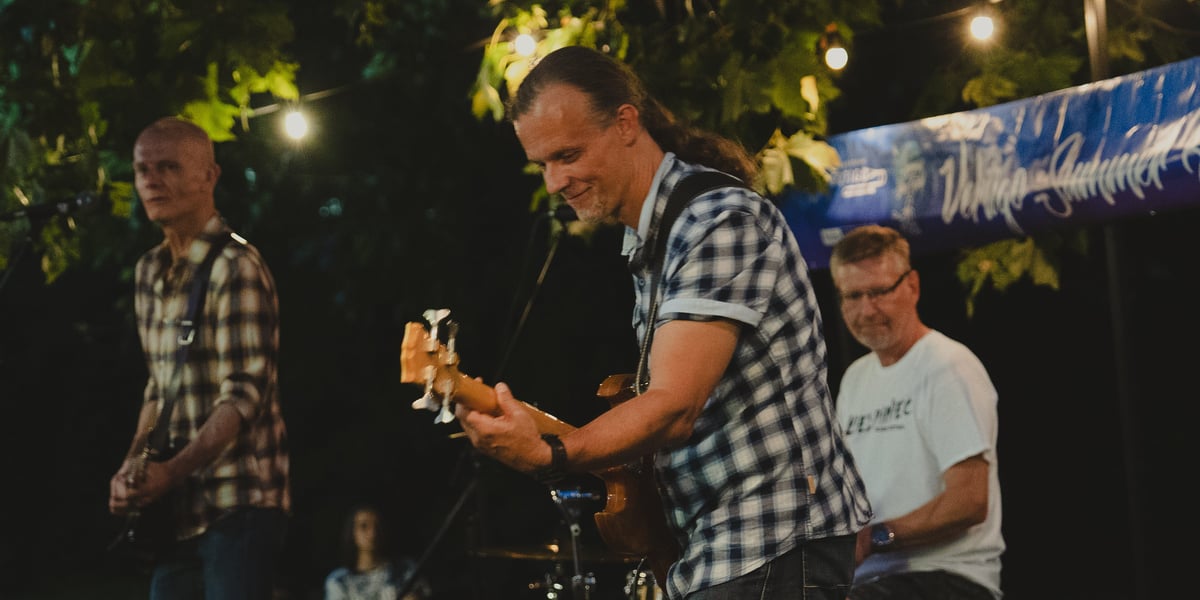 Trzech mężczyzn, dwóch gra na gitarze, jeden na perkusji. Koncert zespołu Outsider między przystankami Rondo a Sztabowa (24.08.2024) 
