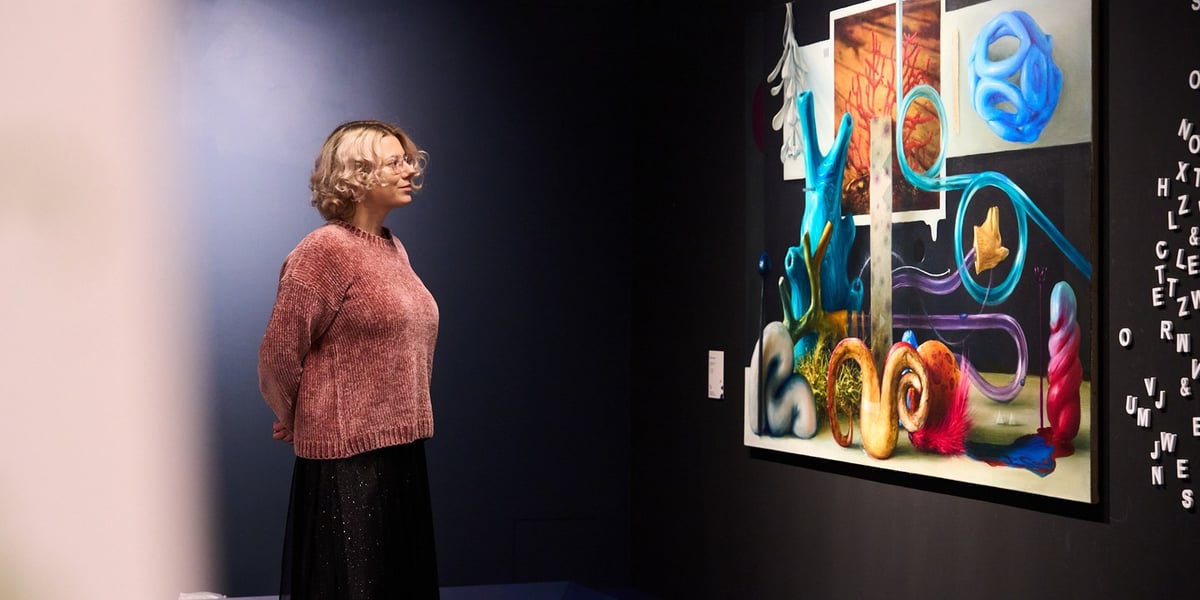 Młoda blondynka patrzy na obraz na wystawie „Nazwa bez wystawy, wystawa bez nazwy” w Krupa Art Foundation