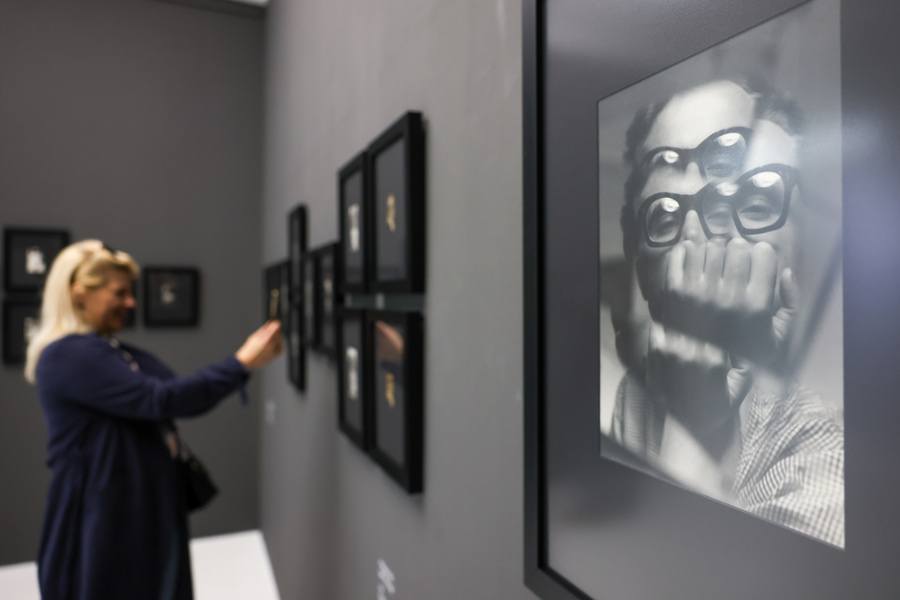 Fotograficzny autoportret Zdzisława Beksińskiego na ścianie Pawilonu Czterech Kopuł, w tle kobieta oglądająca wystawę (13 kwietnia 2025)
