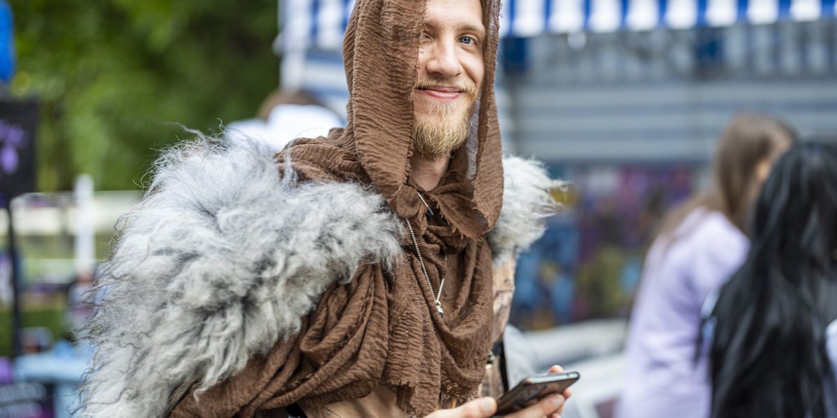Mężczyzna w stroju wikinga ze smartfonem w dłoni, na Dniach Fantastyki 2024 we Wrocławiu