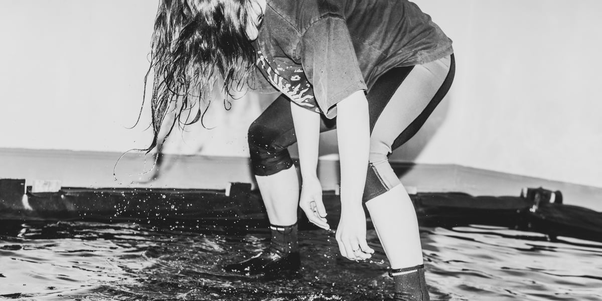 Pochylona aktorka stojąca w wodzie podczas próby w Pantomimie