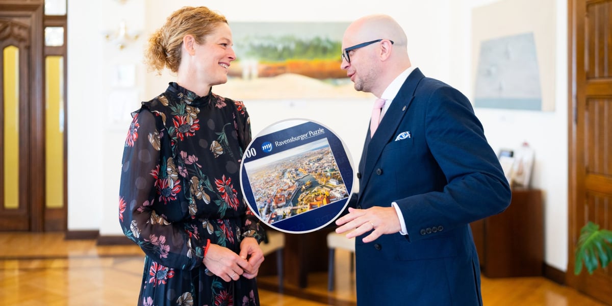 Susanne Knoche i Jakub Mazur podczas spotkania w ratuszu, w kółku są puzzle marki Ravensburger