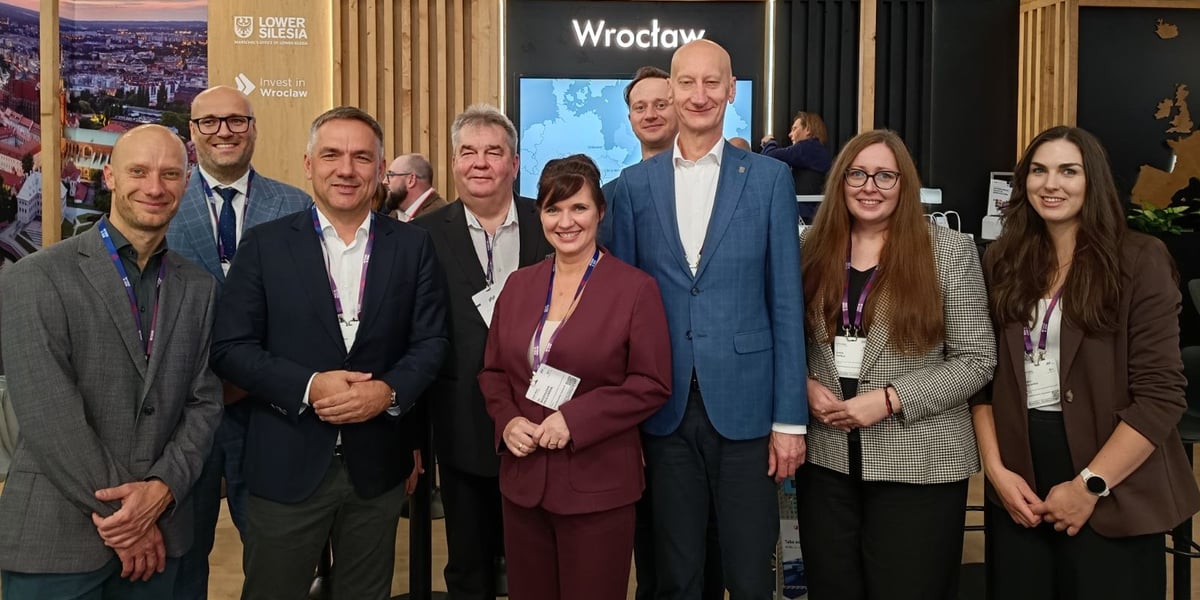 Grupa uśmiechniętych osób pozuje do wspólnego zdjęcia na stoisku Wrocławia i Dolnego Śląska na targach, w tle widać napis „Wrocław” i ekran z mapą. Przedstawiciele Wrocławia i regionu na EXPO REAL 2026 w Monachium.