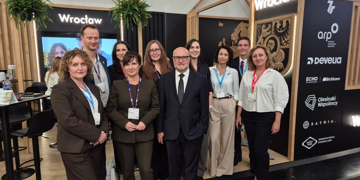 Grupa uśmiechniętych osób pozuje do wspólnego zdjęcia na stoisku Wrocławia i Dolnego Śląska na targach, w tle widać napis „Wrocław” i ekran z mapą. Przedstawiciele Wrocławia i regionu na EXPO REAL 2026 w Monachium.