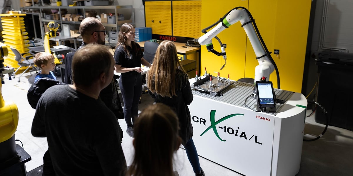 Na zdjęciu grupa ludzi obserwuje pracę robota
